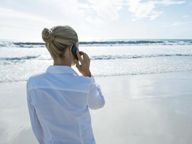 Una mujer hablando por teléfono en la playa./Gtres