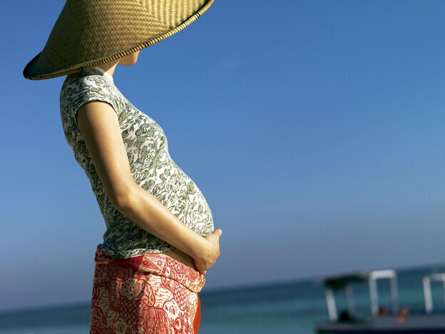 Mujer embarazada frente a la playa/Cordon