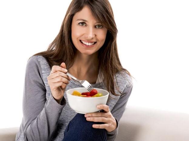 Una mujer, comiendo un bol de frutas./gtres