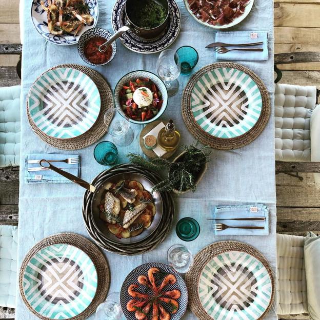 Mesa exterior del hotel con vajilla en tonos turquesa.