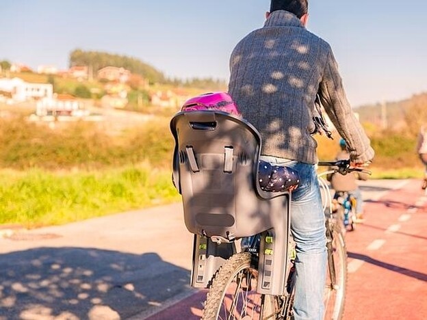 Un padre lleva a su hijo en una silla trasera de bicicleta./FOTOLIA