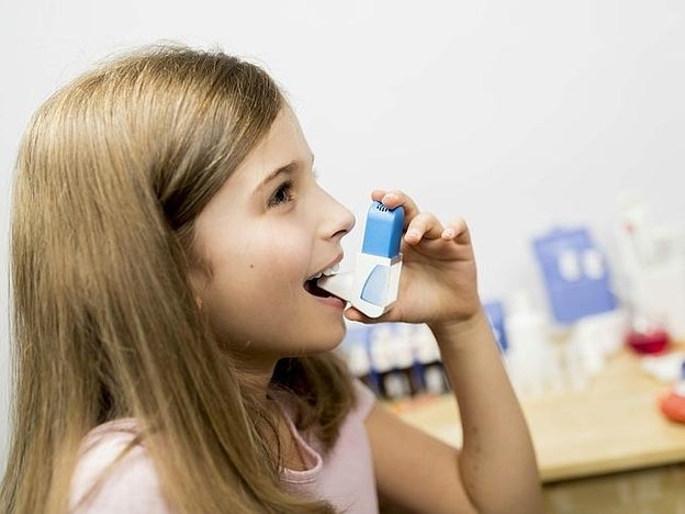 Niña con un ventolín para el asma/Fotolia