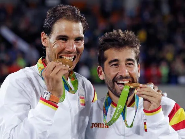 Rafa Nadal y marc López mordiendo su medalla de oro en Río 2016/Gtres