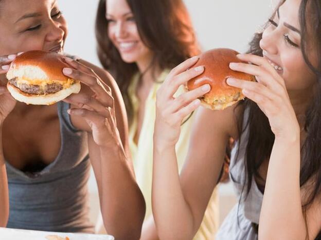 Amigos comiendo pizzas/Getty