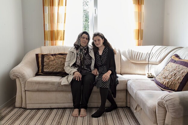 Un hogar provisional. Mina junto a su hija Shiwa, en el sofá de su salón/habitación, en un barracón del campo de refugiados de Hamburgo, en el que conviven con otra familia. Desde hace ocho meses comparten con ellos baño y cocina. Esperan tener pronto su propia casa.