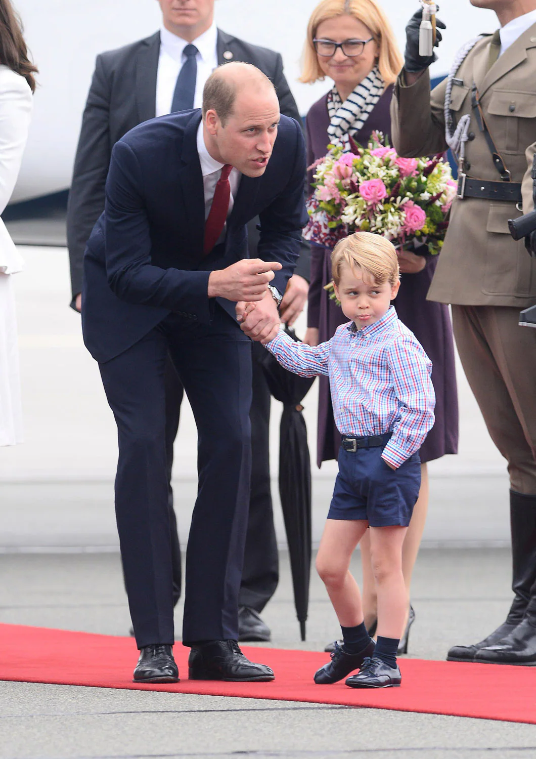 Guillermo lleva de la mano al pequeño Jorge en el aeropuerto de Varsovia