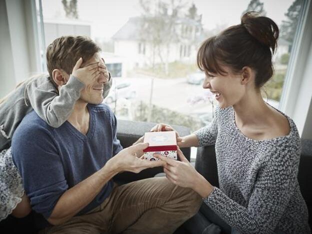 Un padre recibiendo un regalo en familia./getty