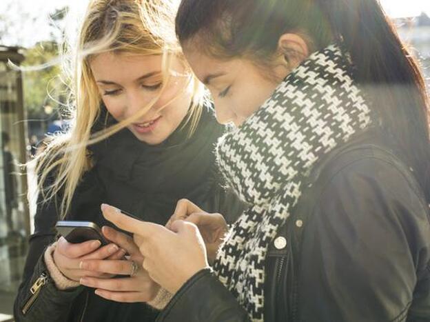 Dos mujeres, consultando el móvil./GTRES