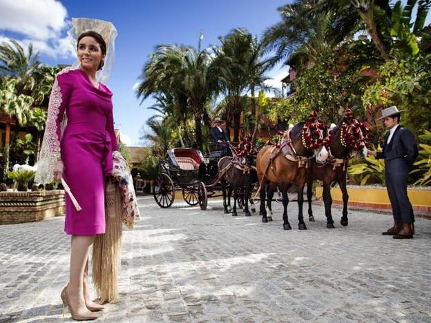 Paloma Segrelles junto a un coche de caballos.