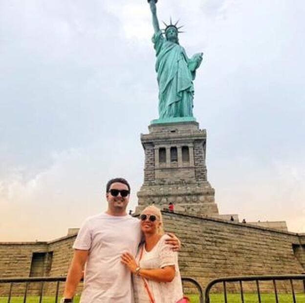 La pareja ante la Estatua de la Libertad.