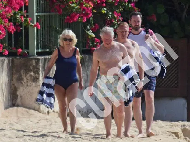 Camila Parker Bowles y el príncipe Carlos de Inglaterra dando un paseo por la playa durante su viaje oficial a Barbados./aGENCIAS