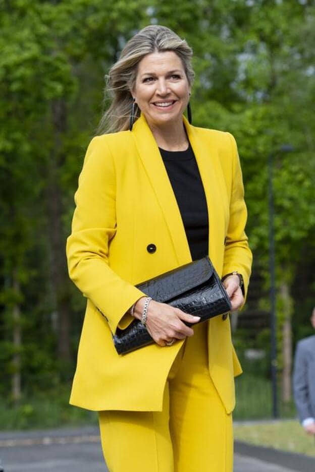 Máxima de Holanda ha combinado su traje amarillo de Zara con complementos en negro.