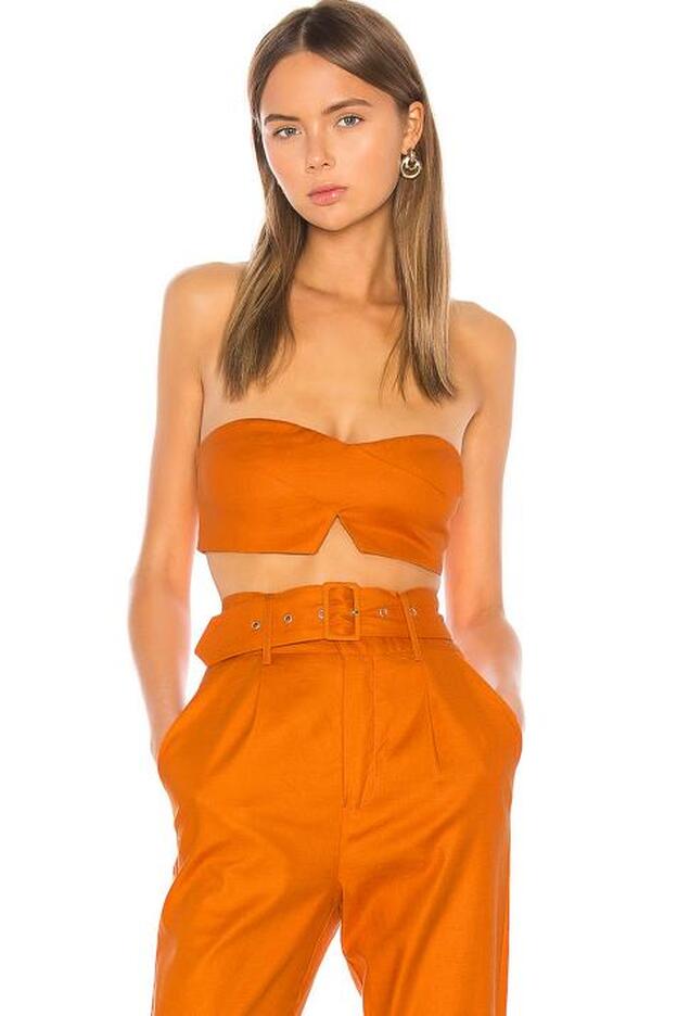 Así aparece el conjunto de top y pantalón naranja en la tienda onlne Revolve.