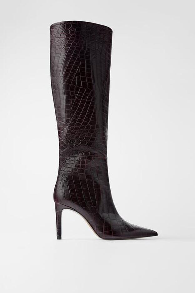 Las botas de piel con estampado de serpiente en color burdeos son de Zara.