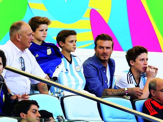 David Beckham con su padre y sus hijos, en un partido de fútbol.