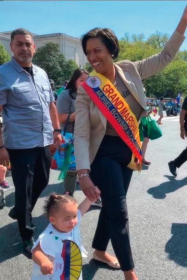 Muriel Bowser con su hija Miranda, paseando por Washington DC con la banda de alcaldesa.