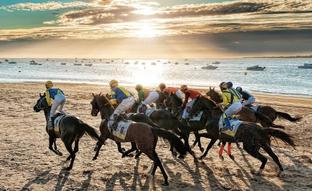 Destino Cádiz: carreras de caballos en la playa con el atardecer de Doñana de fondo