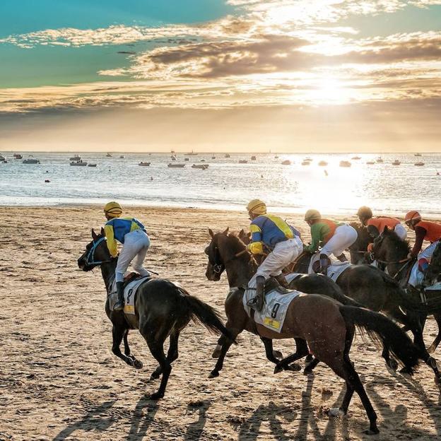 Destino Cádiz: carreras de caballos en la playa con el atardecer de Doñana de fondo