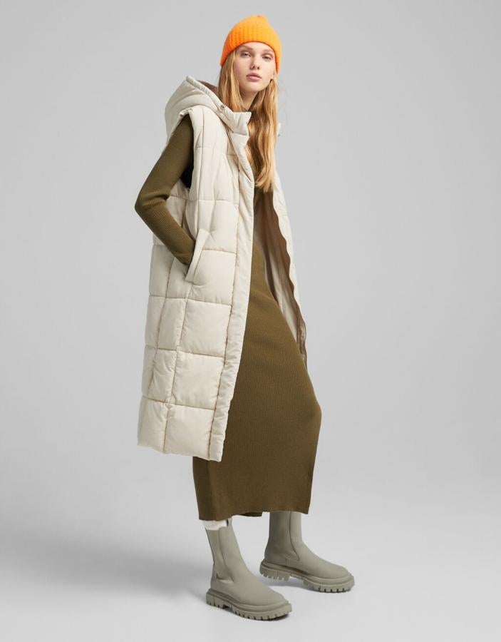 Los chalecos acolchados largos son la prenda tendencia para un look con vestido de punto a la última