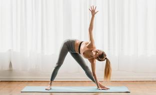 Trikonasana, la postura del triángulo en yoga es pura gasolina para tus brazos y tus rodillas