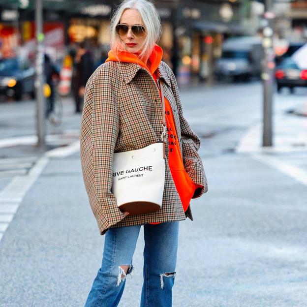 Abrigo de cuadros, sudadera y botas cowboy: el look cómodo y estiloso para la oficina que rejuvenece a los 50