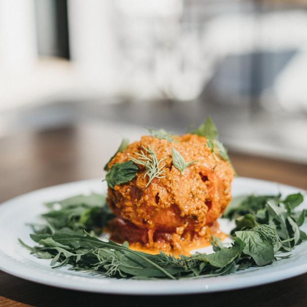 Tomate de la isla, pesto de tomates secos, queso mahón, rúcula y albahaca. 