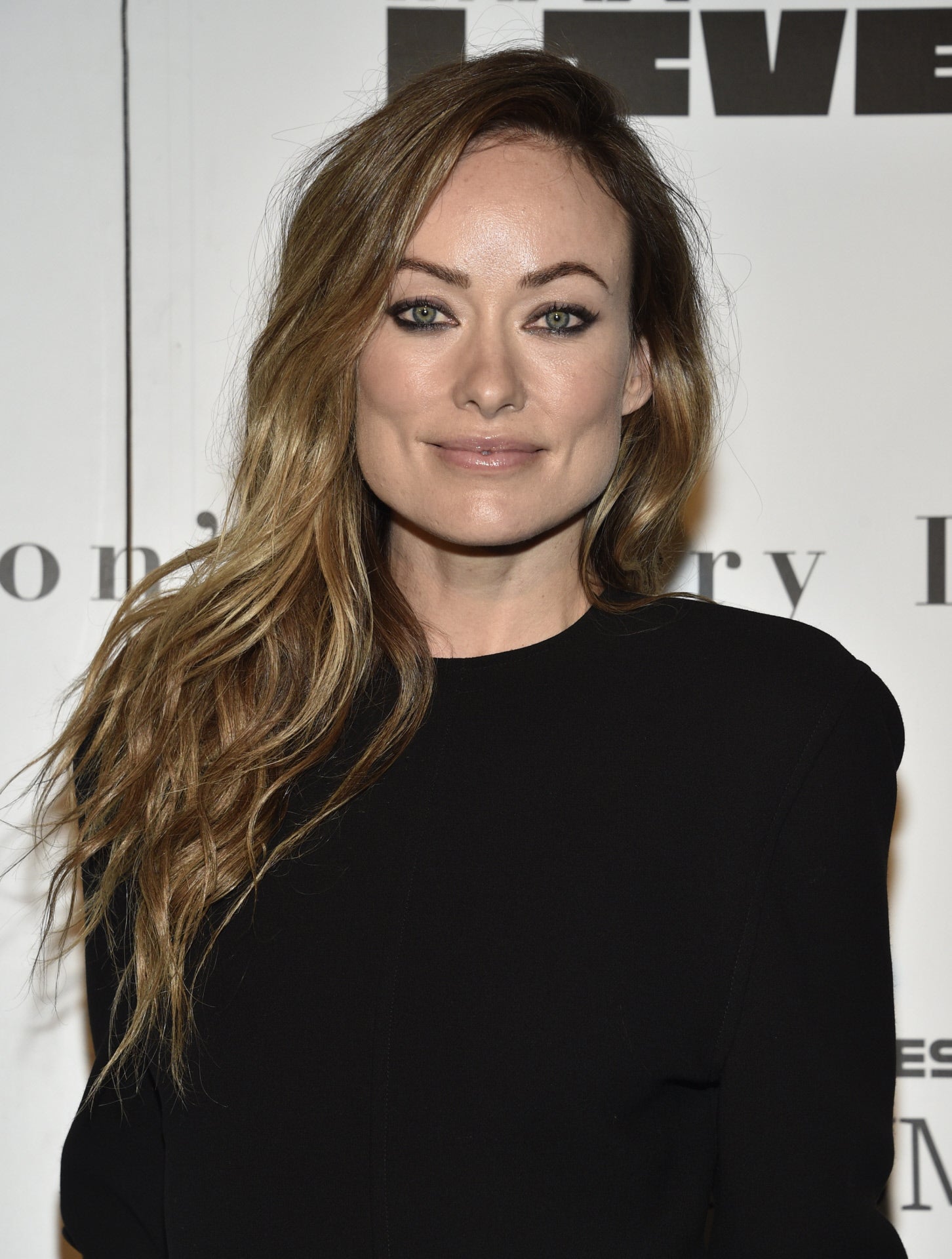 Olivia Wilde o cómo llevar con estilo un vestido negro de punto básico que le vamos a copiar mucho más barato en Zara