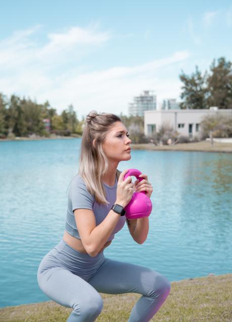 Mujer realizando una sentadilla con pesas/PEXELS