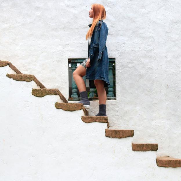 Mujer ascendiendo por una escalera.