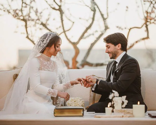 Los novios, sonrientes y felices en el momento de los anillos. 