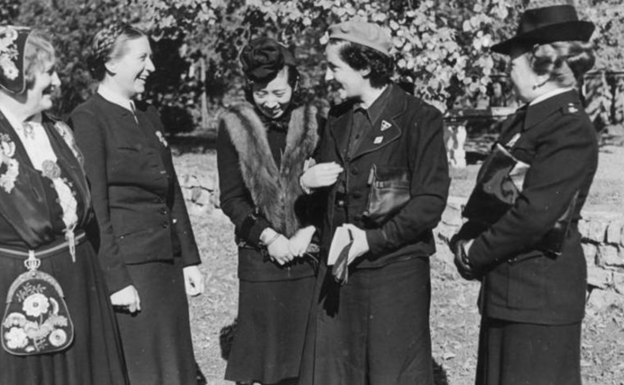 Pilar Primo de Rivera en el centro de la imagen, con boina y guantes en la mano. 