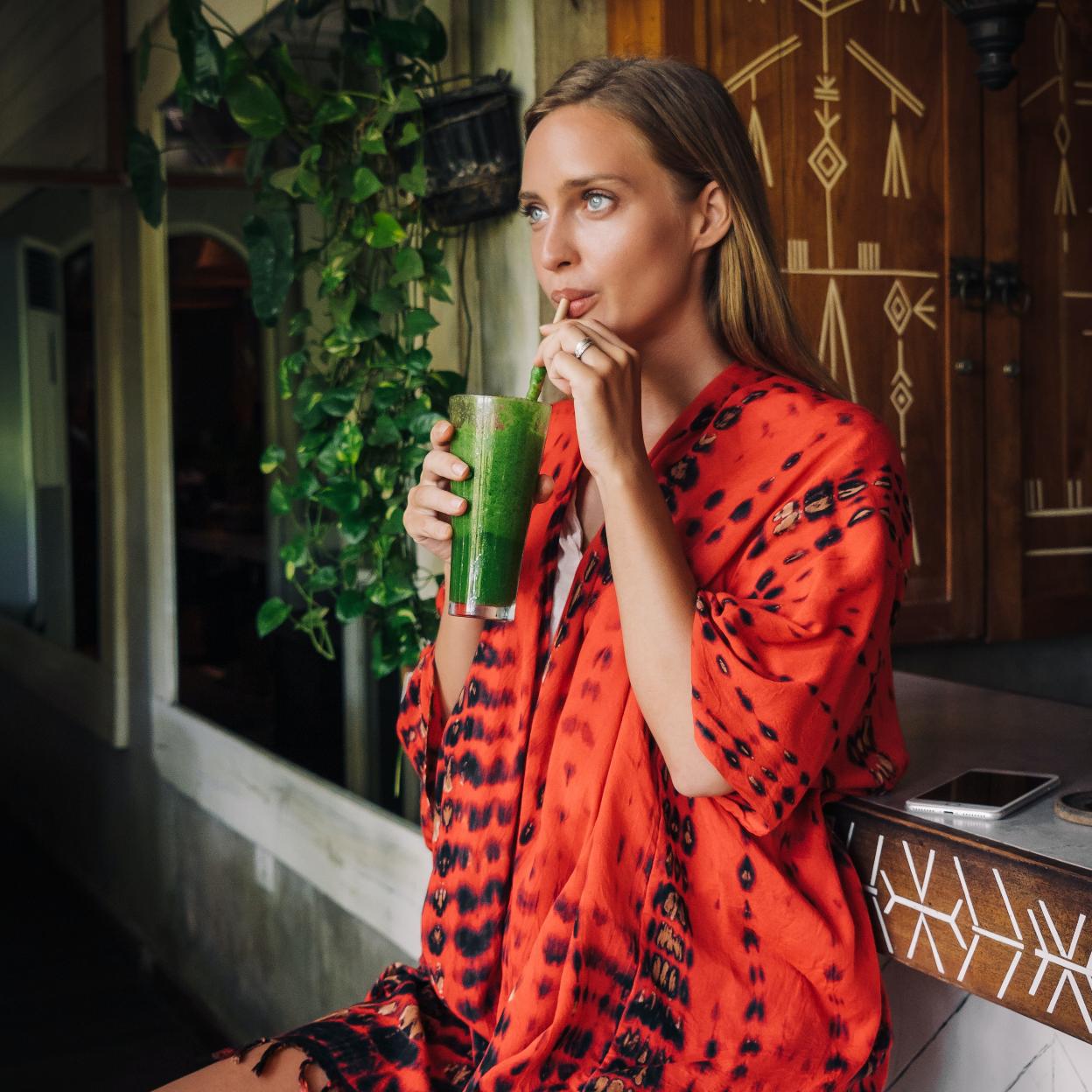 Mujer tomando un zumo verde/pexels