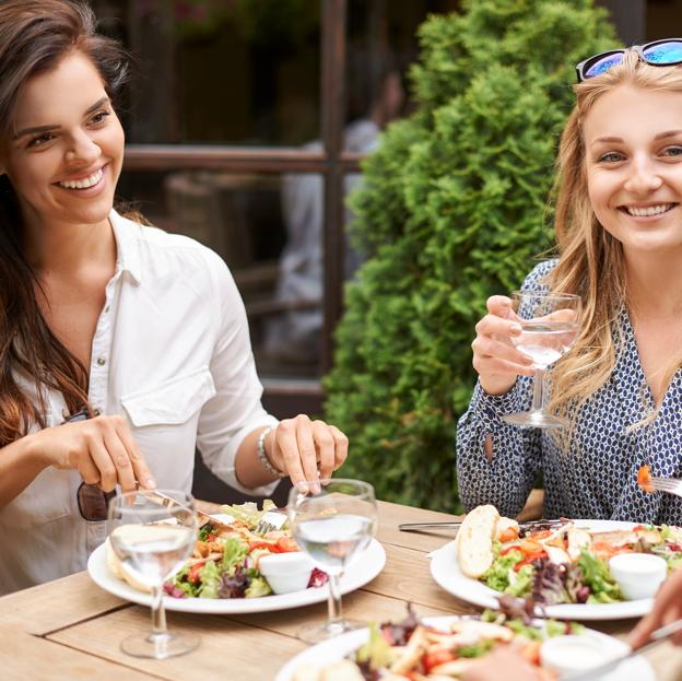 Dos amigos están cenando en un restaurante. 