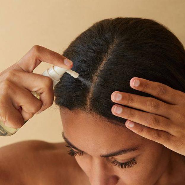 Mujer aplicando agua de romero para el pelo