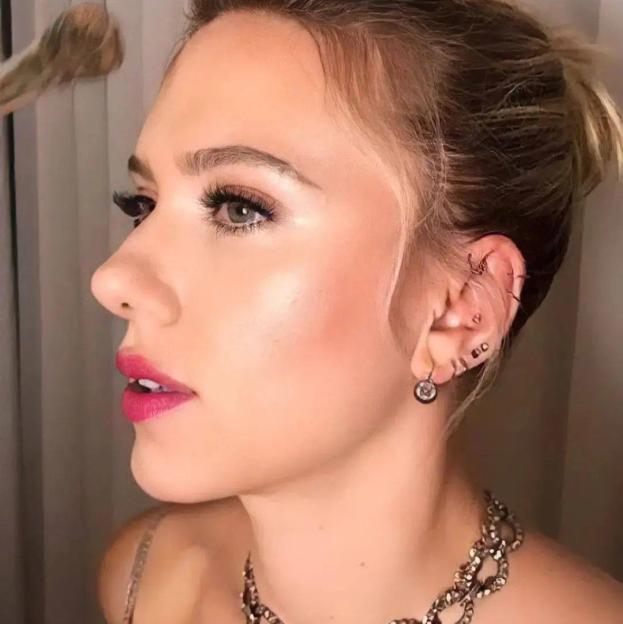 Scarlett Johansson con piercings en la oreja rodeando el lóbulo