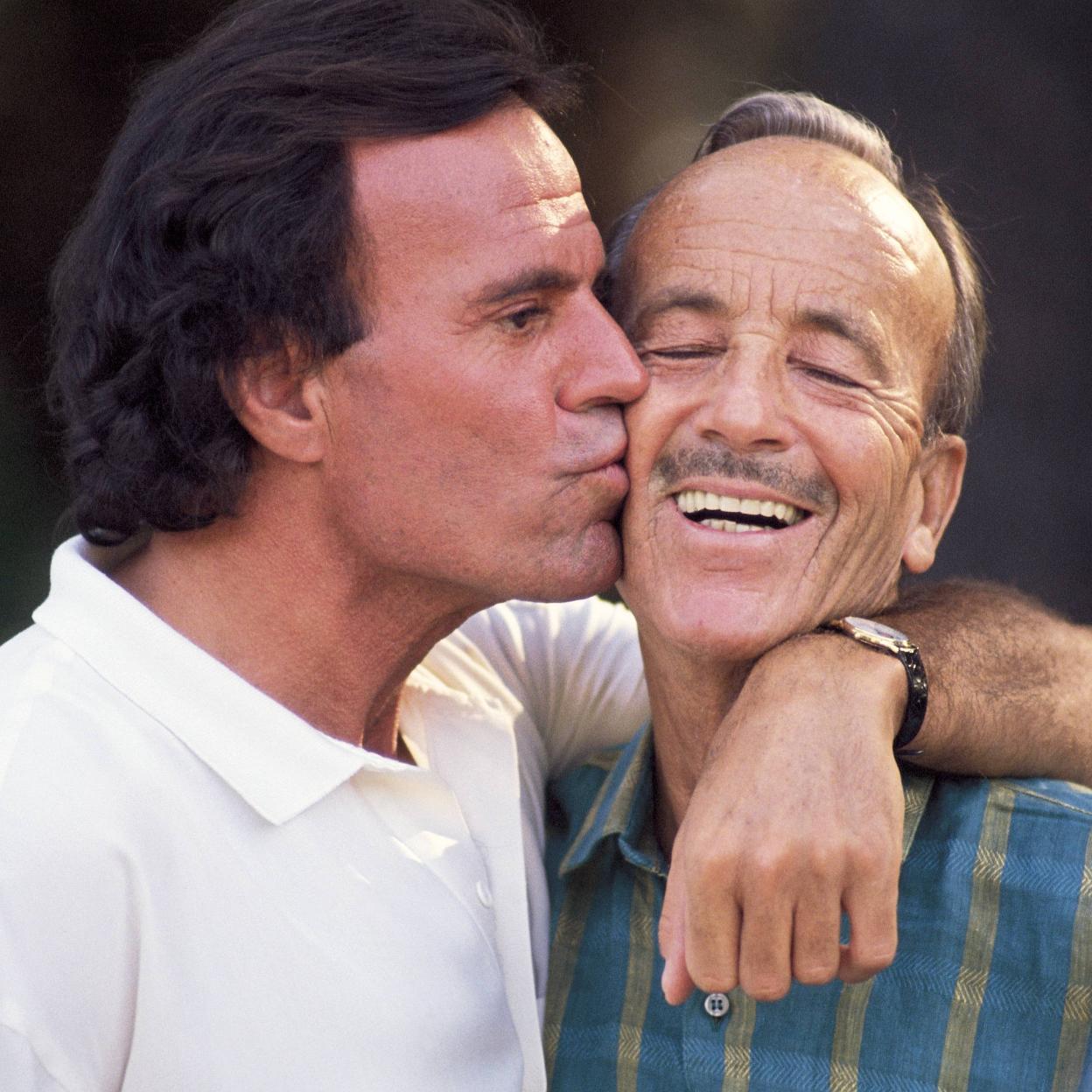 El cantante Julio Iglesias besa a su padre, el doctor Iglesias Puga, más conocido como Papuchi. /Getty