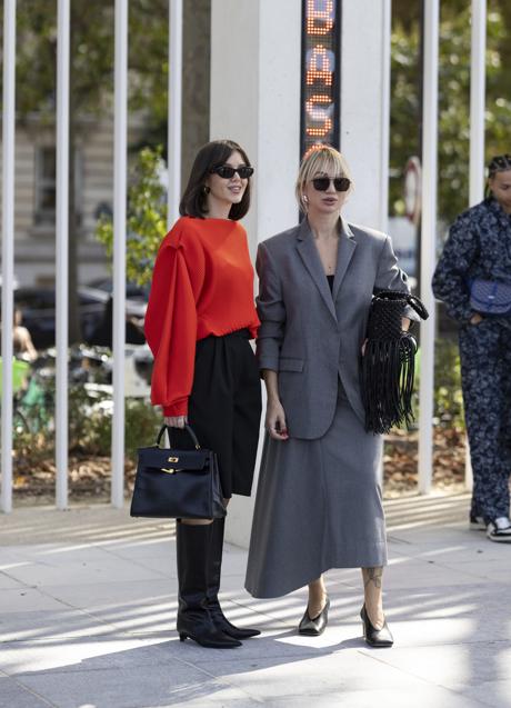 Dos mujeres con looks en rojo y gris en el street style. Foto: Launchmetrics spotlight.