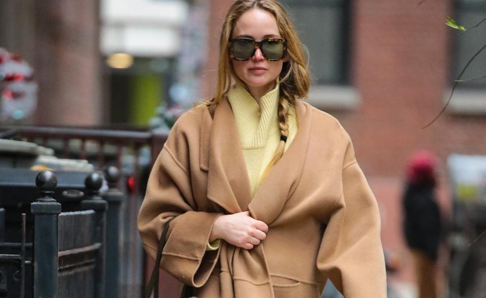 El abrigo camel de Jennifer Lawrance está en Mango y lo ha combinado en un look cómodo con zapatillas