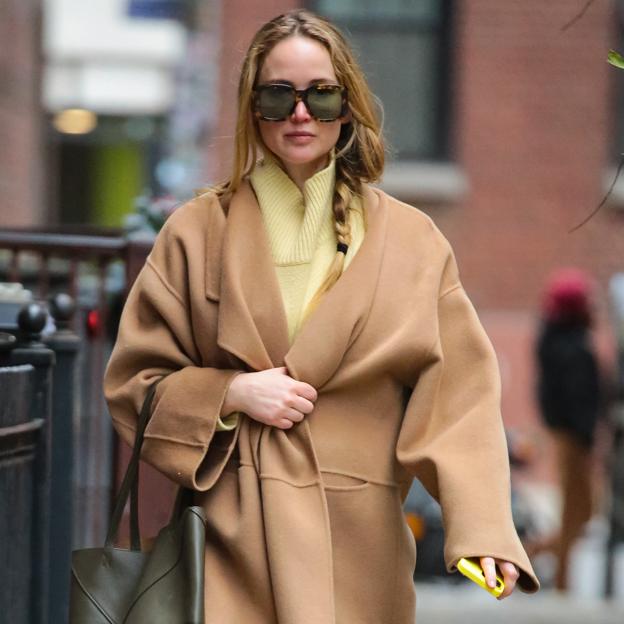 El abrigo camel de Jennifer Lawrance está en Mango y lo ha combinado en un look cómodo con zapatillas