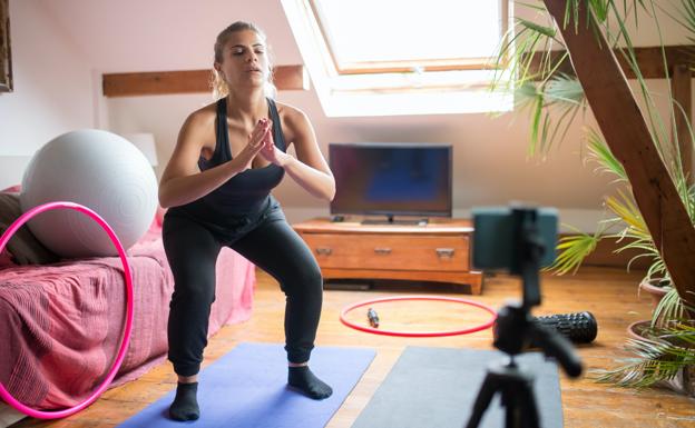 Mujer realizando sentadillas en su casa. /