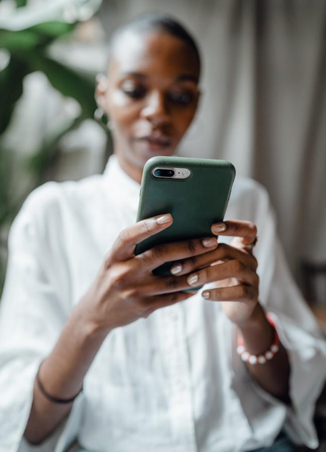 Mujer haciendo scroll con el dedo en su móvil. / PEXELS