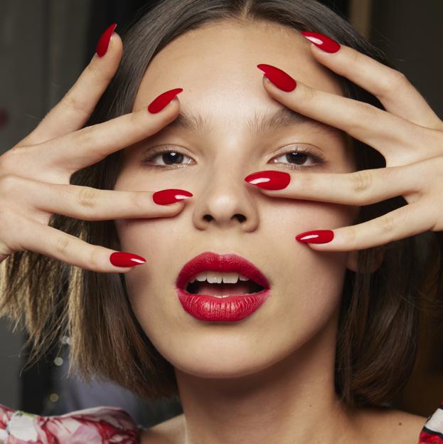 Una modelo con una manicura roja.