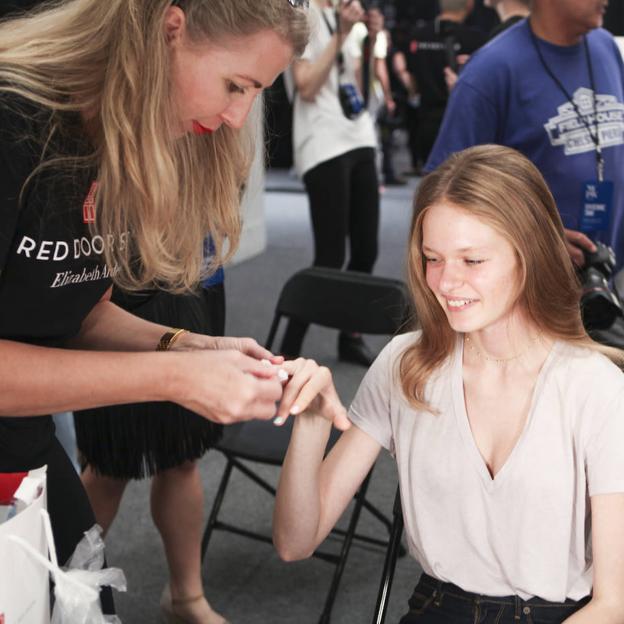 Manicurista limando uñas a modelo