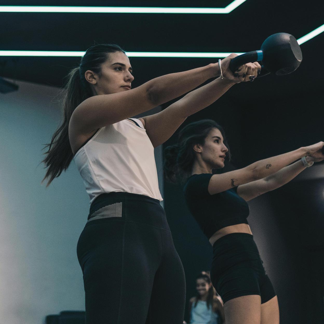 Dos chicas entrenando con pesas rusas/pexels