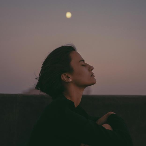 Mujer con luna llena de fondo