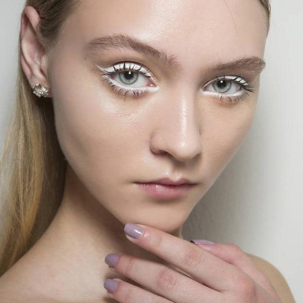 Modelo con maquillaje de ojos usando lápiz blanco