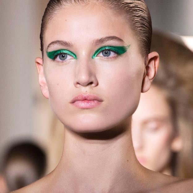 Modelo con lápiz de ojos verde