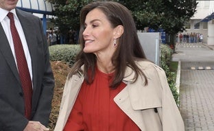 La reina Letizia viaja a Milán con un vestido rojo y gabardina para presidir el acto central del Día Mundial de la Investigación en Cáncer