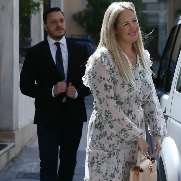 Teodora de Grecia, con su ya marido detrás, luciendo un vestido de flores boho y bolso de Louis Vuitton. 