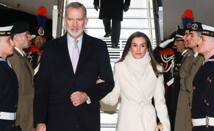 La reina Letizia sorprende en su llegada a Italia con un impoluto look blanco: abrigo largo y zapatos metalizados